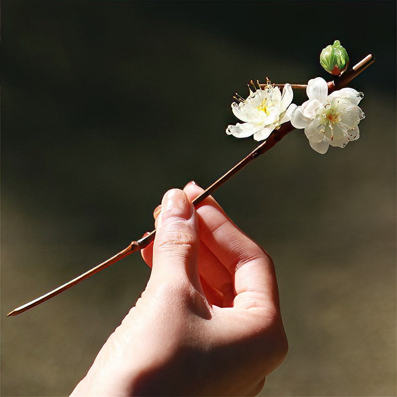 Close-up of painted green flowers and subtle sheen on hair stick surface