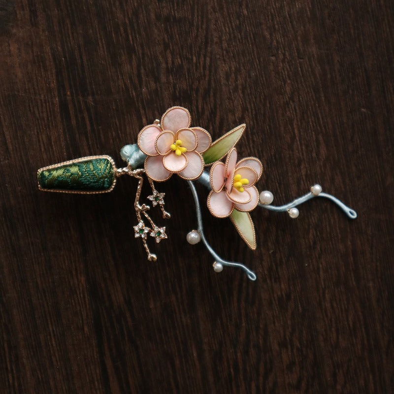 Brooch pinned to fabric edge showcasing size and soft pink color in daylight
