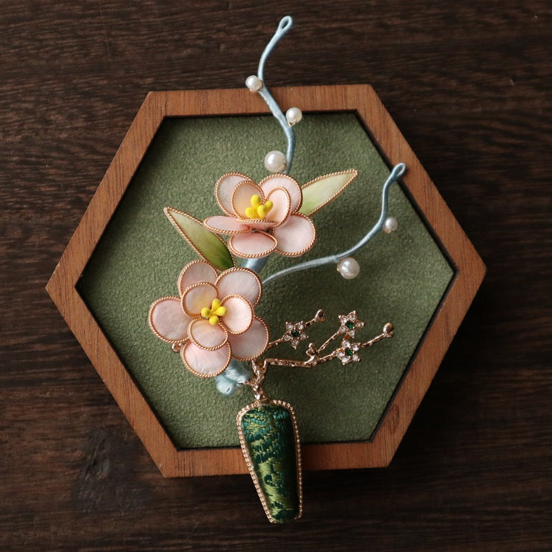 Close-up of blush petal layers and pearled accents against dark cloth