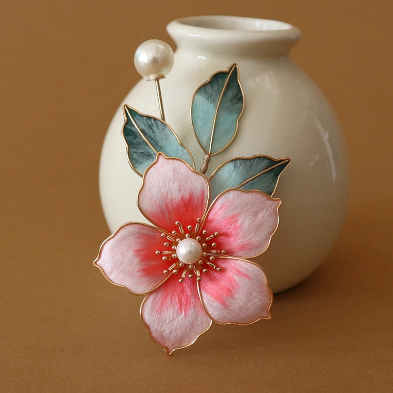 Side view of brooch highlighting layered velvet-look petals and pearly bead cluster