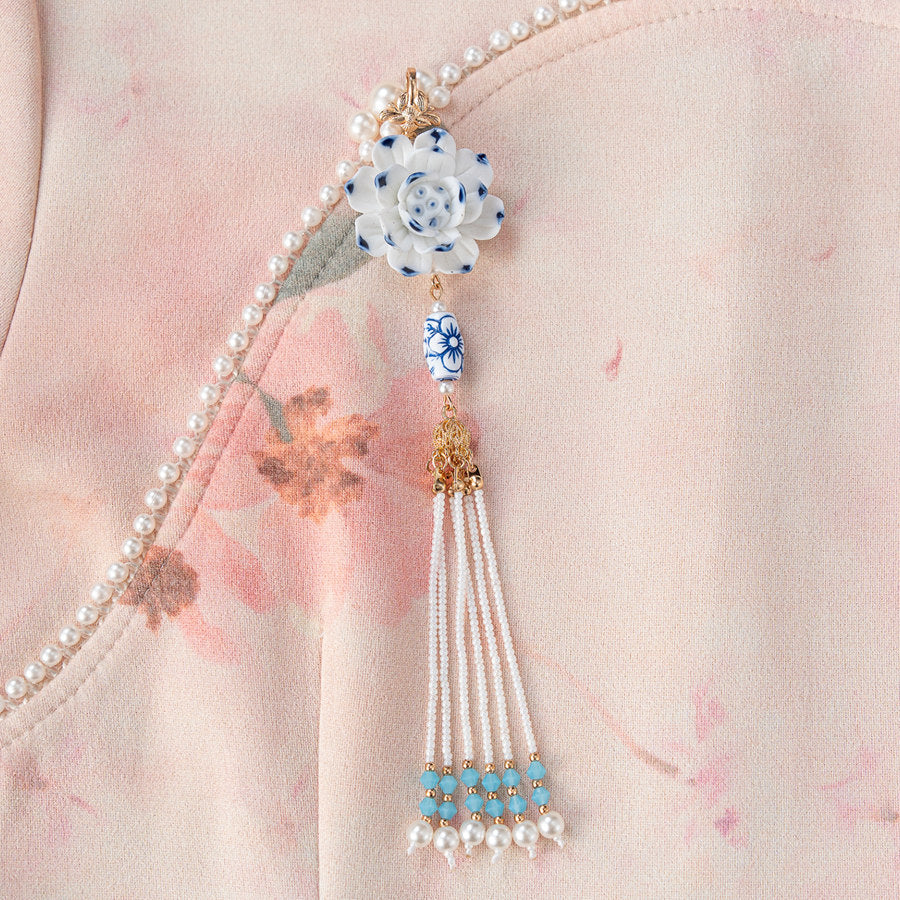 Gold-finish butterfly-shaped brooch resting on deep red qipao neckline