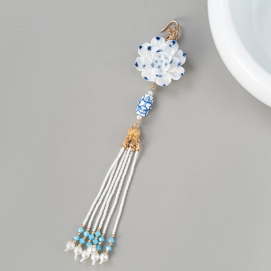 Close-up of delicate filigree-inspired pinback and pearly center on dress
