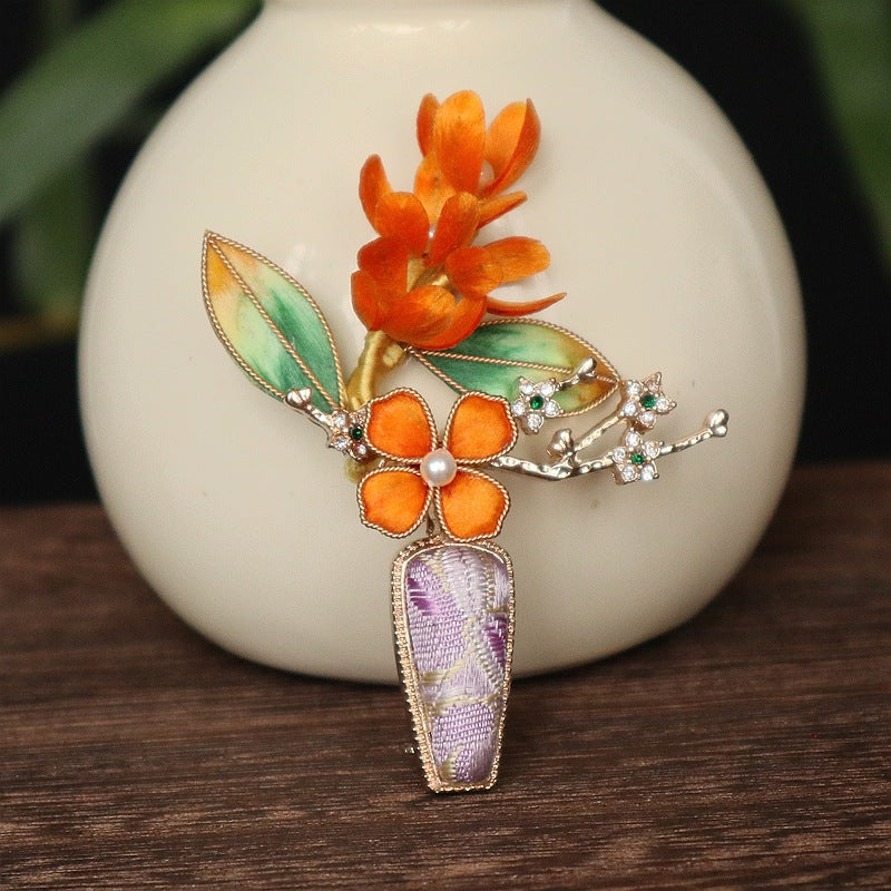purple velvet vase-inspired brooch on dark fabric