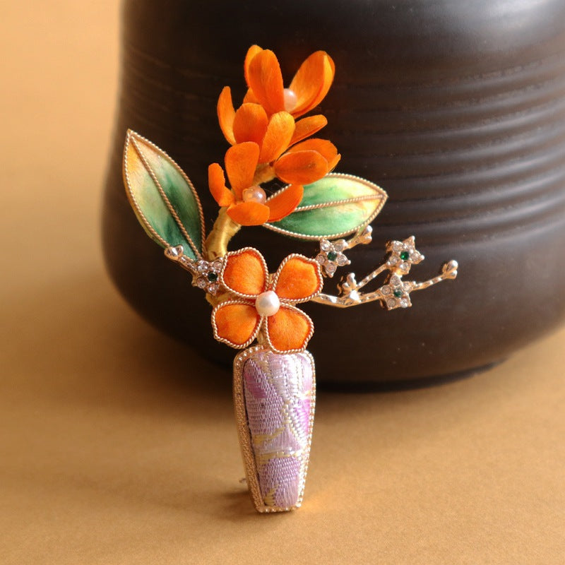 purple velvet vase-inspired brooch on dark fabric viewed close up