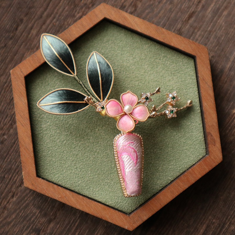 floral vase-inspired brooch pin on a dress styled for an occasion