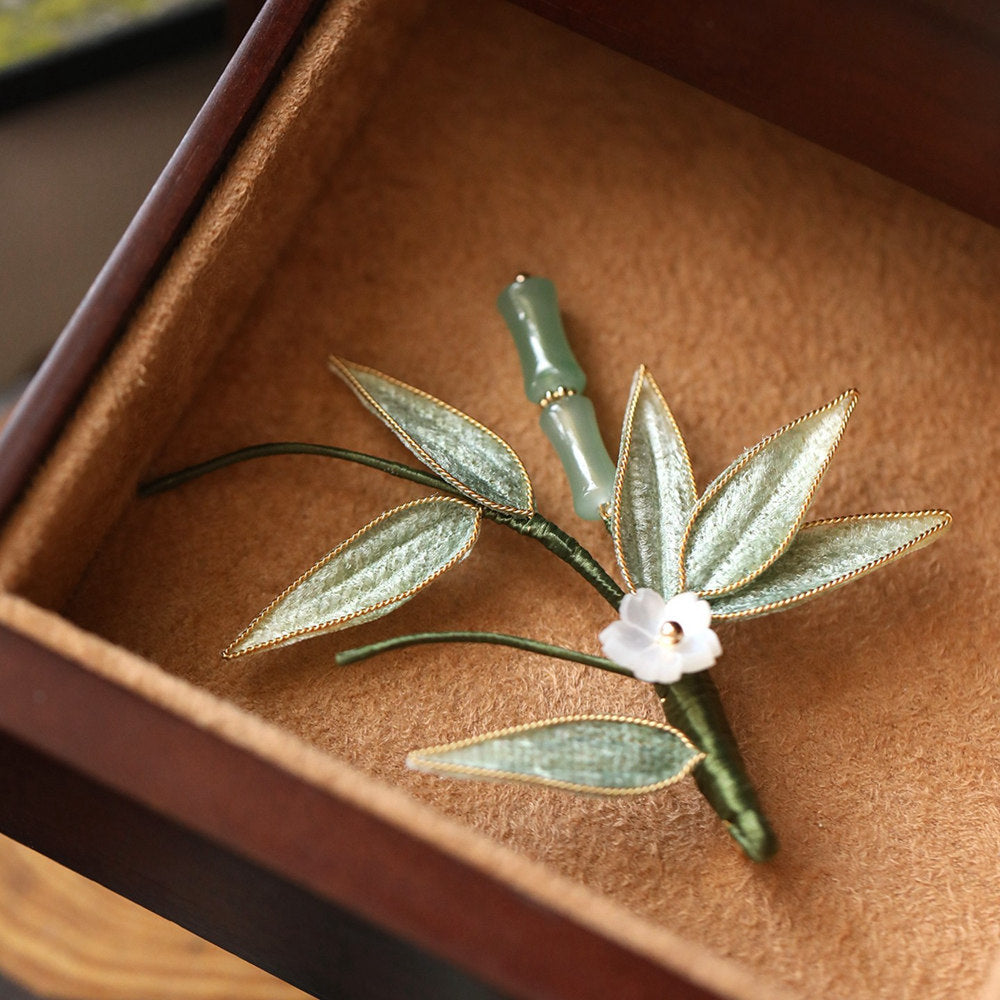 bamboo leaf brooch nestled in a black gift box with cushioned lining