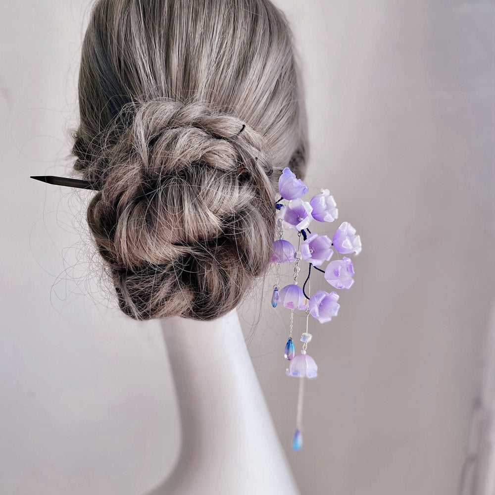 Back view of bun secured with floral stick, tassel hanging down