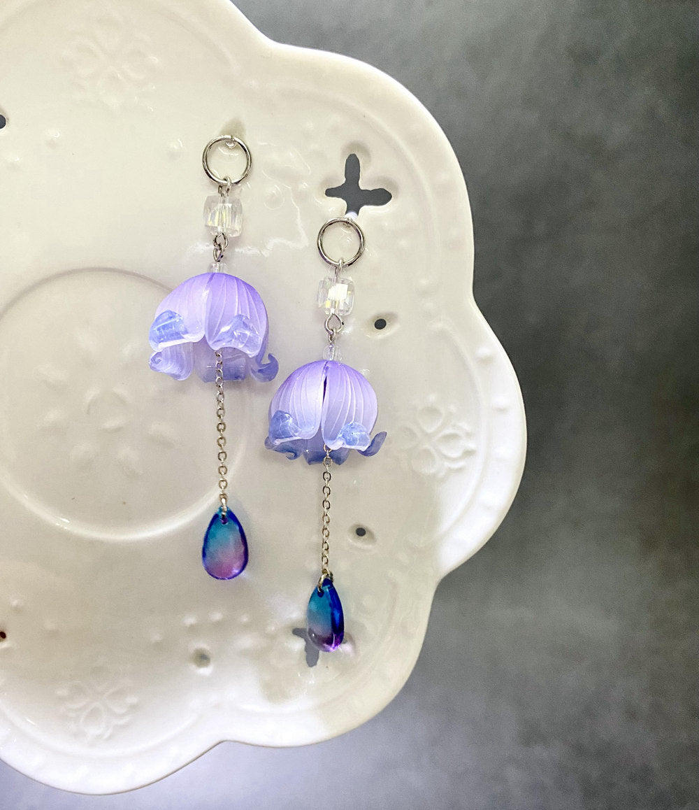 Purple floral hair stick paired with matching statement earrings displayed