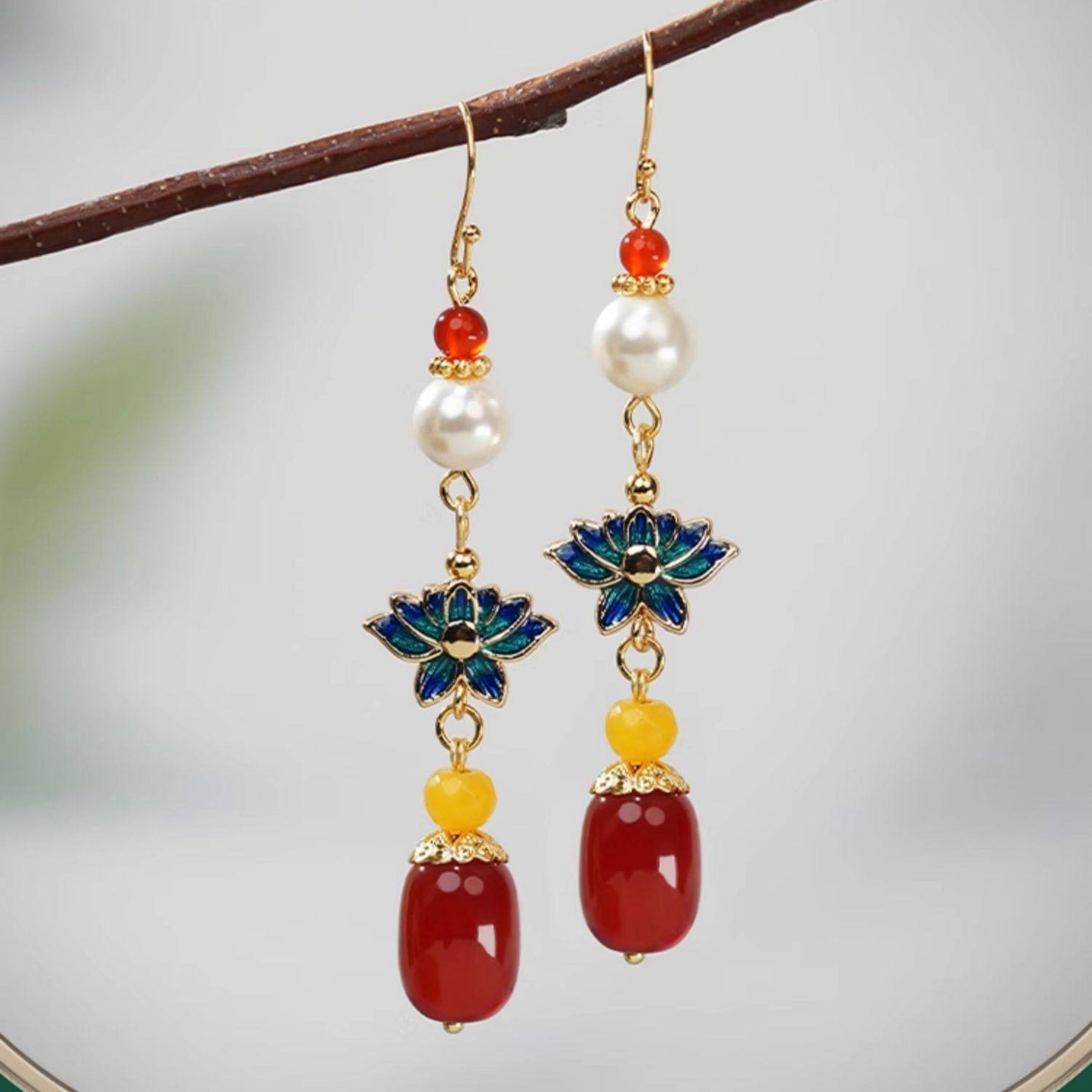 Blue lotus and red bead drops earrings, worn styling view