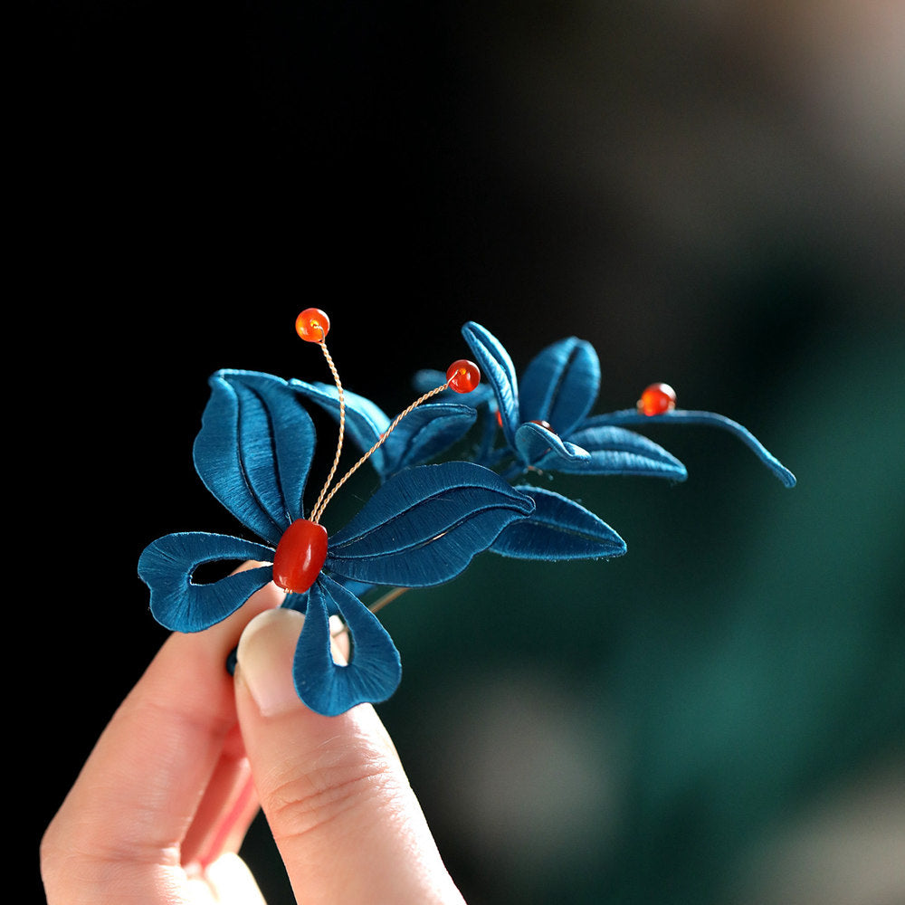 Side view of the brooch held by hand showing the profile and pin clasp