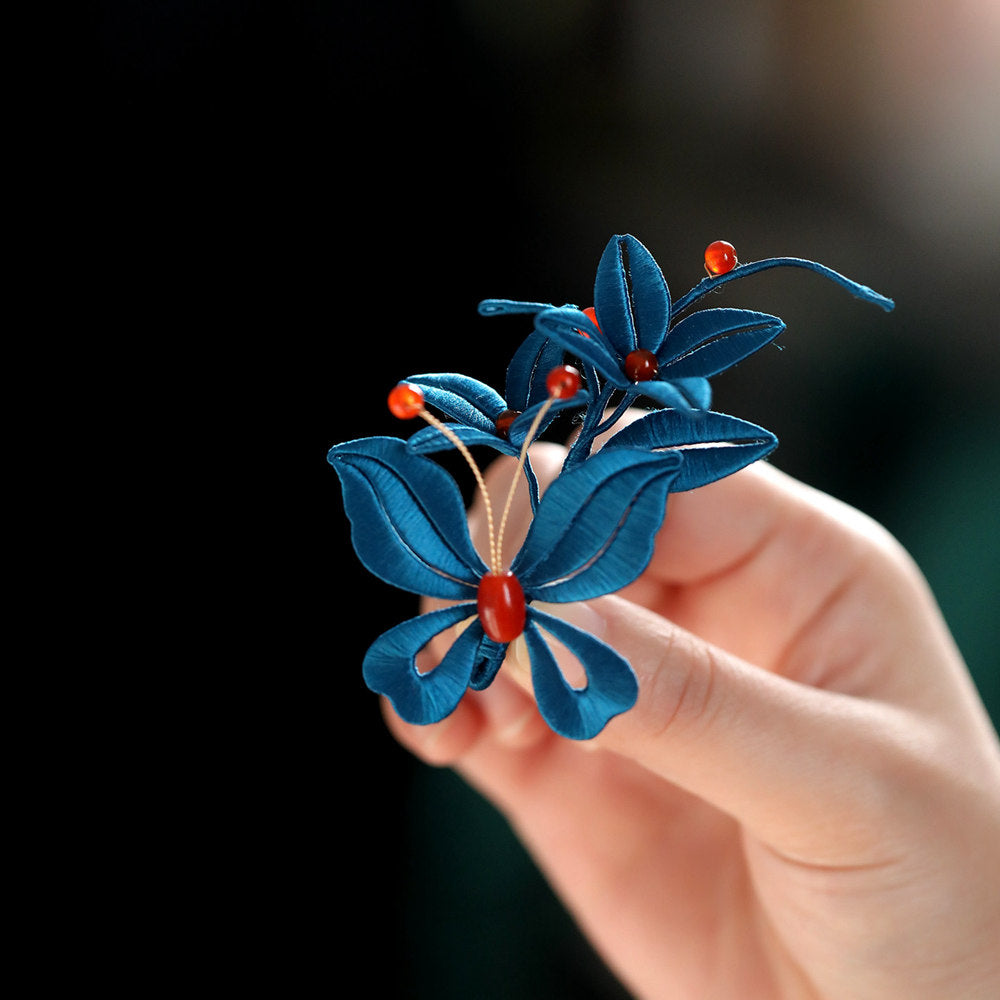 Front view of the blue floral pin held against fabric highlighting color