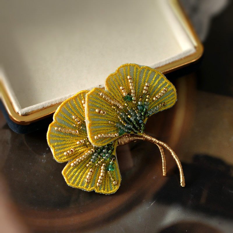 Brooch nestled inside gift box with tissue, warm lighting, elegant presentation