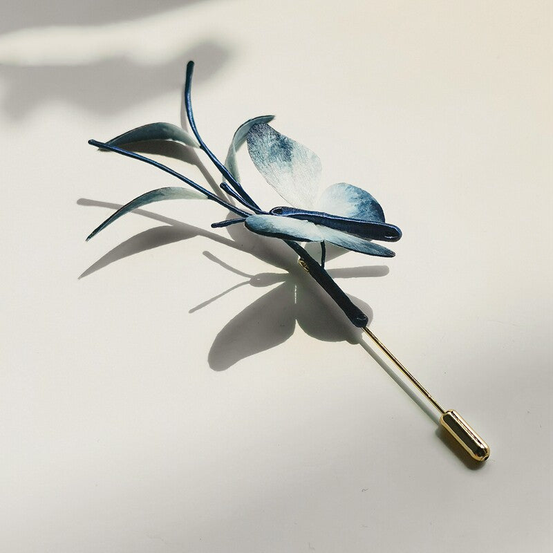 Angled view of dragonfly pin resting on a neutral background