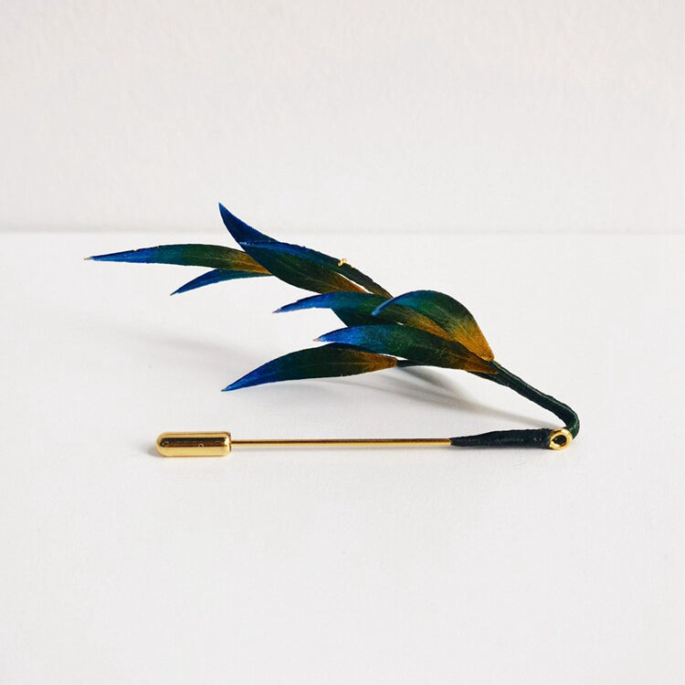 Side view showing layered leaves and blue-green enamel-like sheen on pin