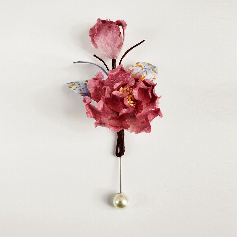 pink floral brooch pin with pearl drop on a coat