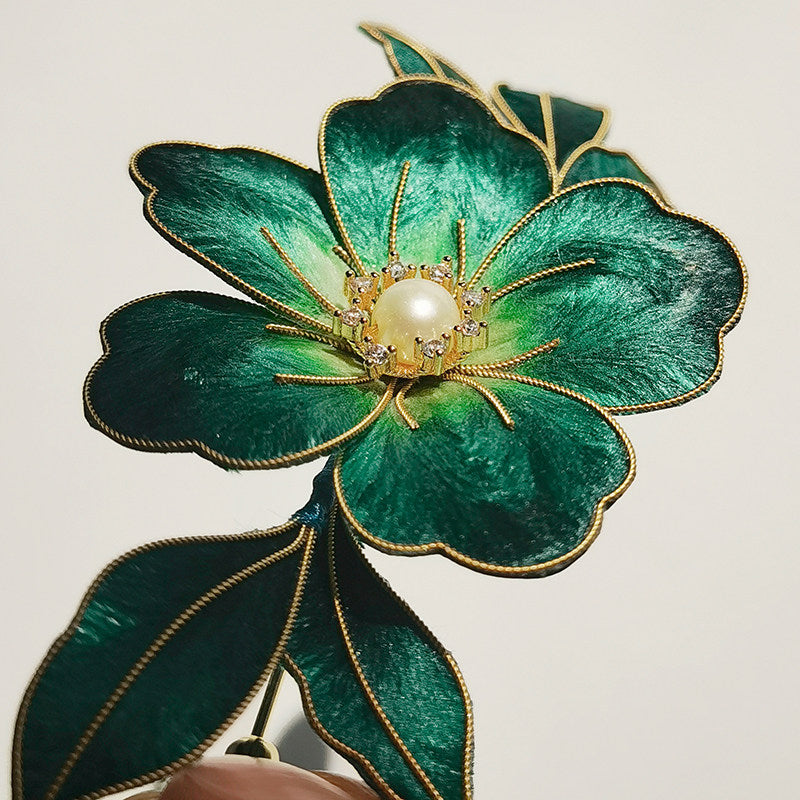 Close-up of the brooch center highlighting a pearl-like accent and textured petals