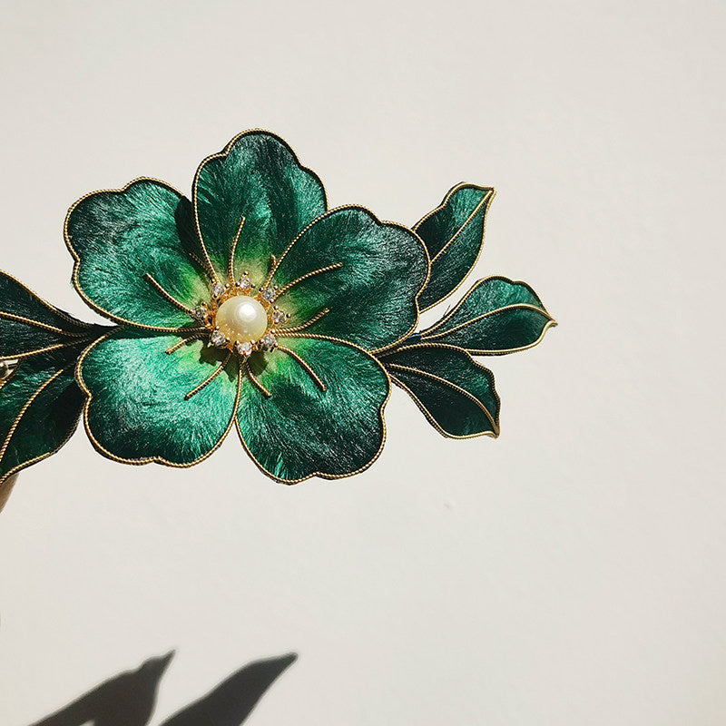 Front view of botanical-inspired brooch with balanced leaves and openwork petal silhouette