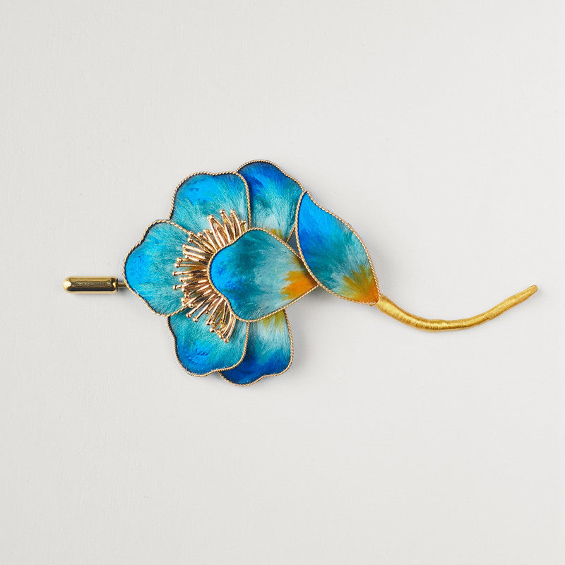 Horizontal view of floral design pinned on blazer, soft blue tones shown
