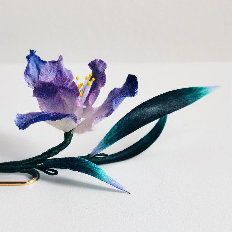 purple iris brooch pin styled on a blazer viewed close up