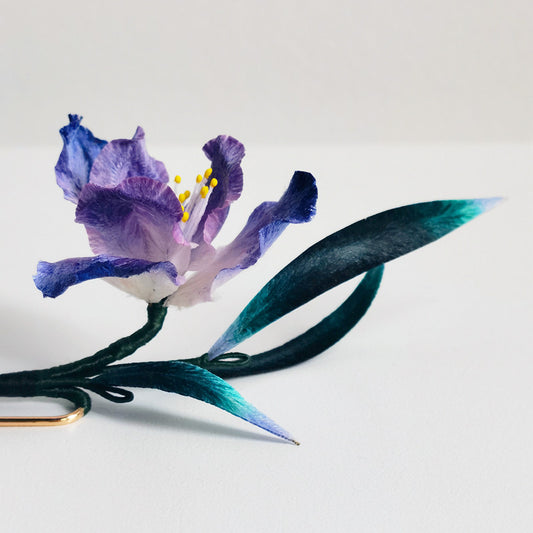 purple iris brooch pin styled on a blazer viewed close up