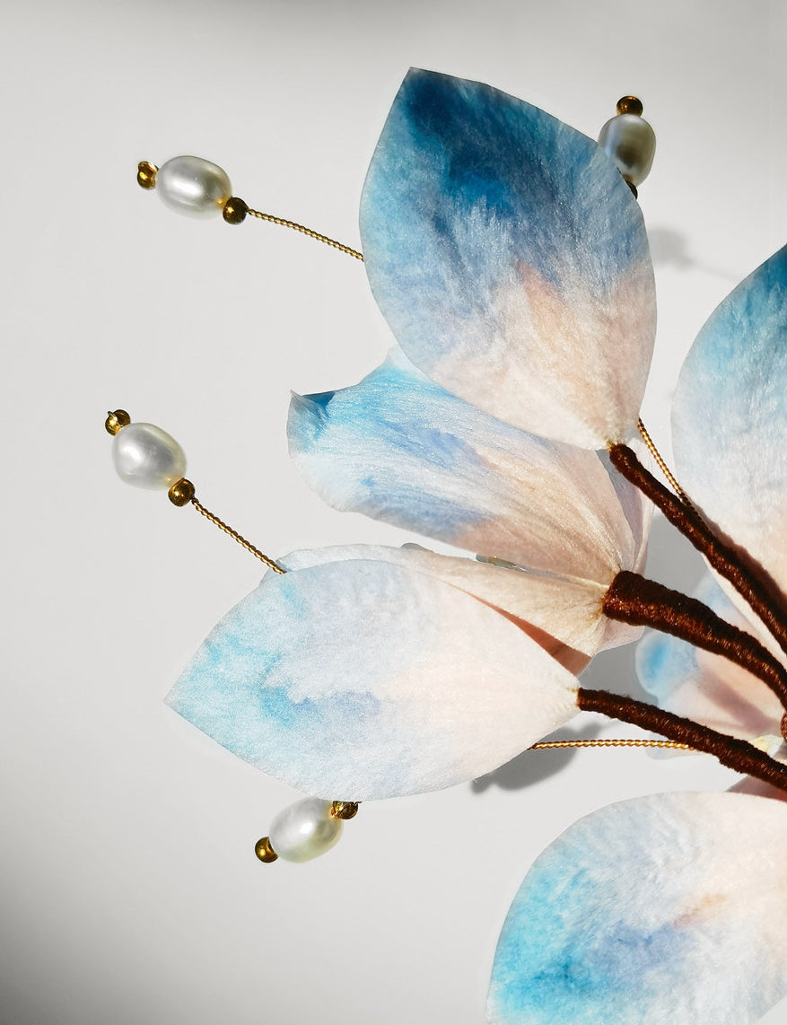 Close-up of bead accents and textured petal edges in pale blue tone