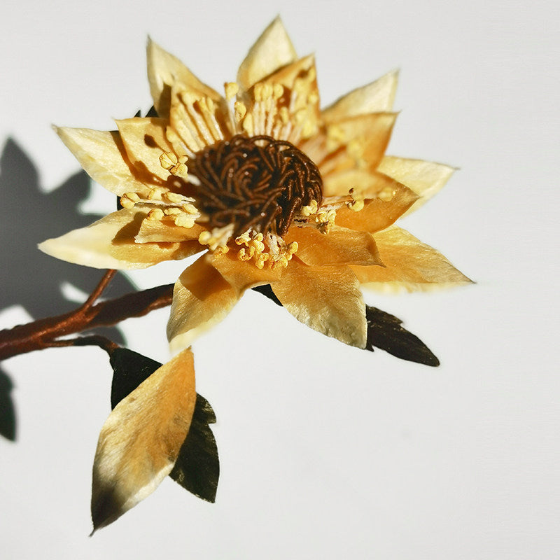 sunflower brooch pin styled on a sweater displayed on fabric