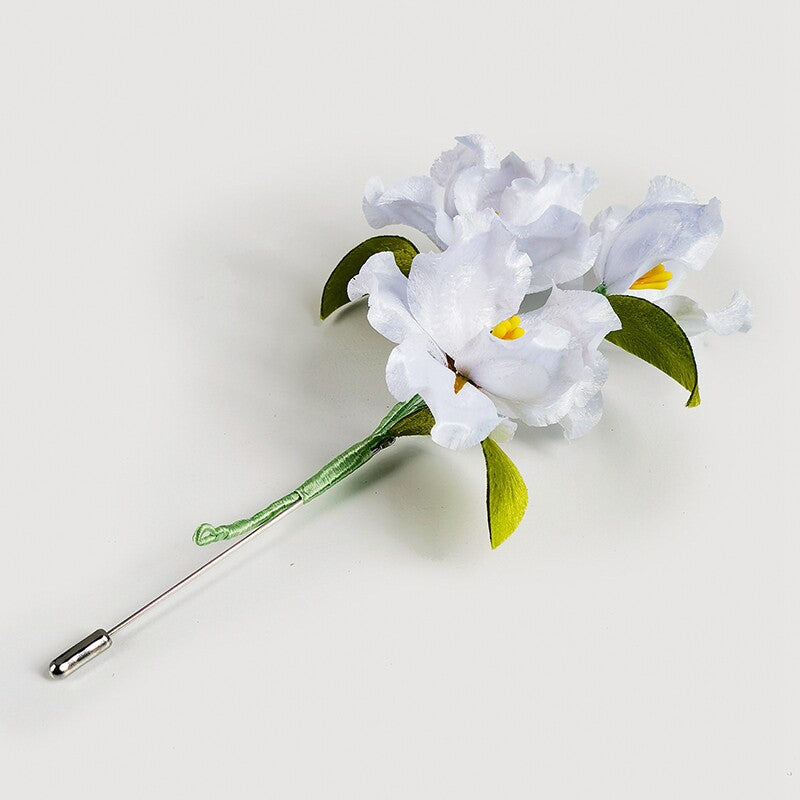 white lily brooch pin on a wedding guest dress