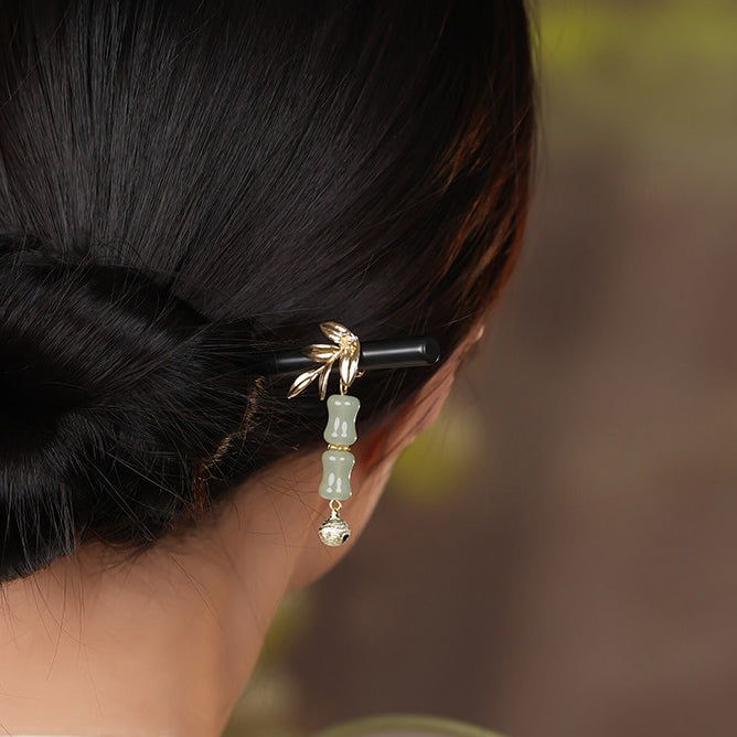 Styled in an elegant updo, showing a lightweight black stick with green accent