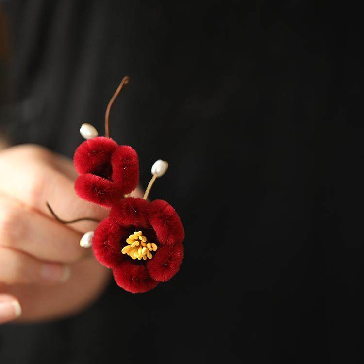 Front view of soft layered flower pin fastened to a knit sweater