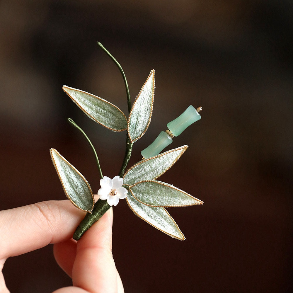 hand holding brooch to show detailed veinwork and pearly bead accent