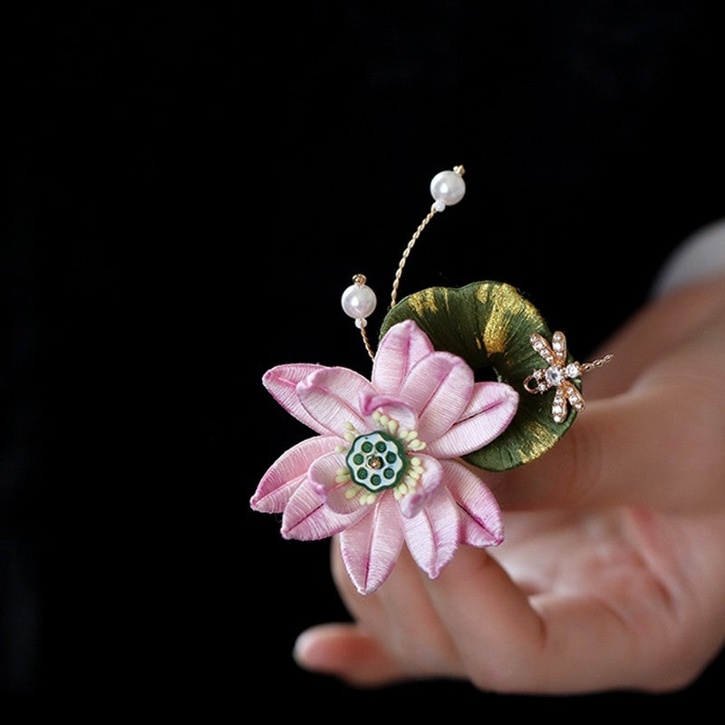 Handheld close-up showing layered petals and pearl-look accent details