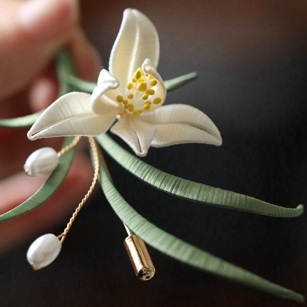 minimal orchid brooch pin styled on a cardigan styled for an occasion