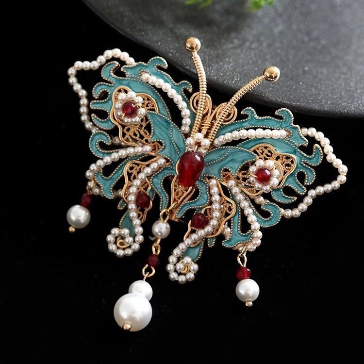 butterfly statement brooch with pearl drop detail viewed close up