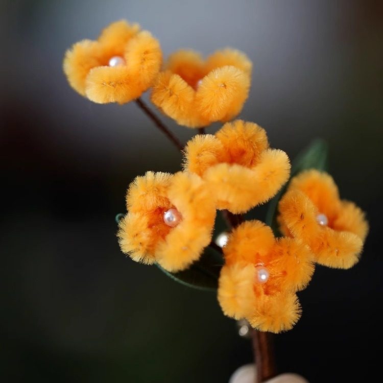 osmanthus-inspired floral brooch on a winter coat