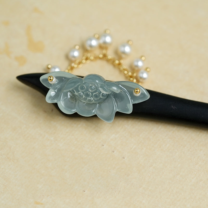 Close-up of lotus motif and delicate metalwork on dark stick