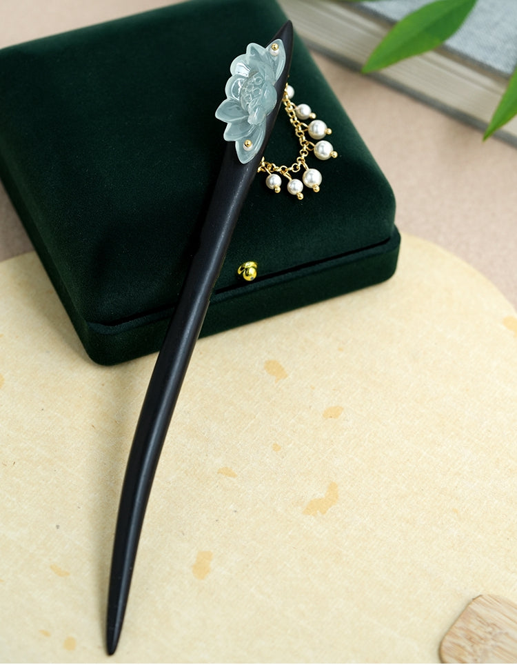 Full-length view of smooth dark stick showing tapered end and ornament