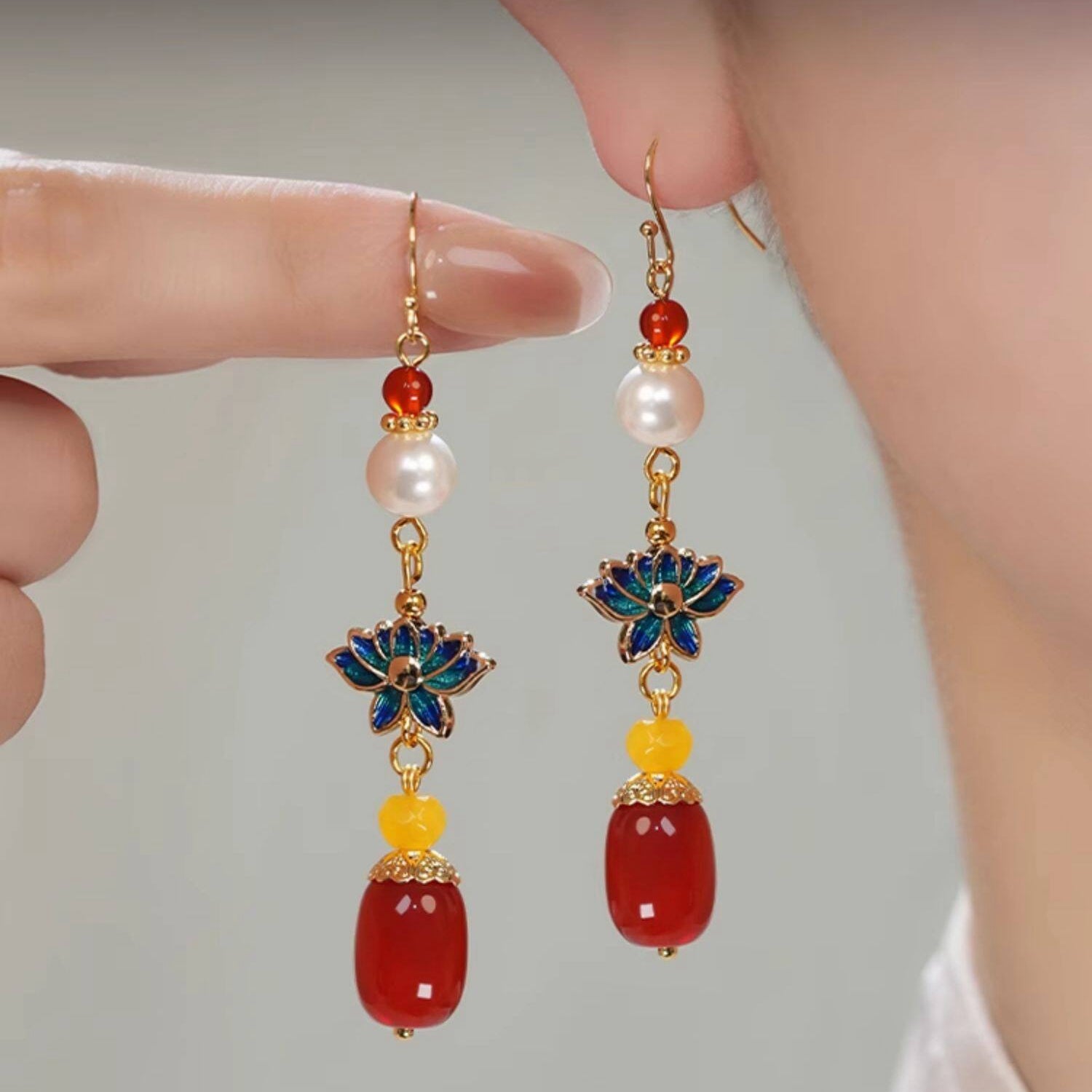 Blue lotus and red bead drops earrings, front view