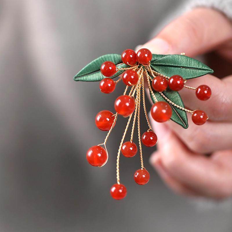 Front close-up of clustered red berries with tiny pearl-like accents visible