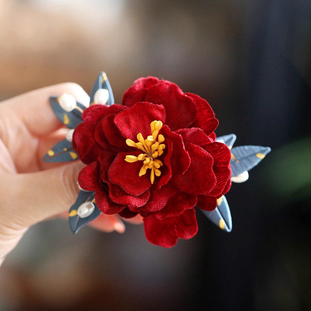 red camellia bridal brooch pin on a dress styled for an occasion