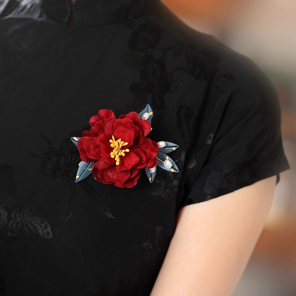 red camellia bridal brooch pin on a dress