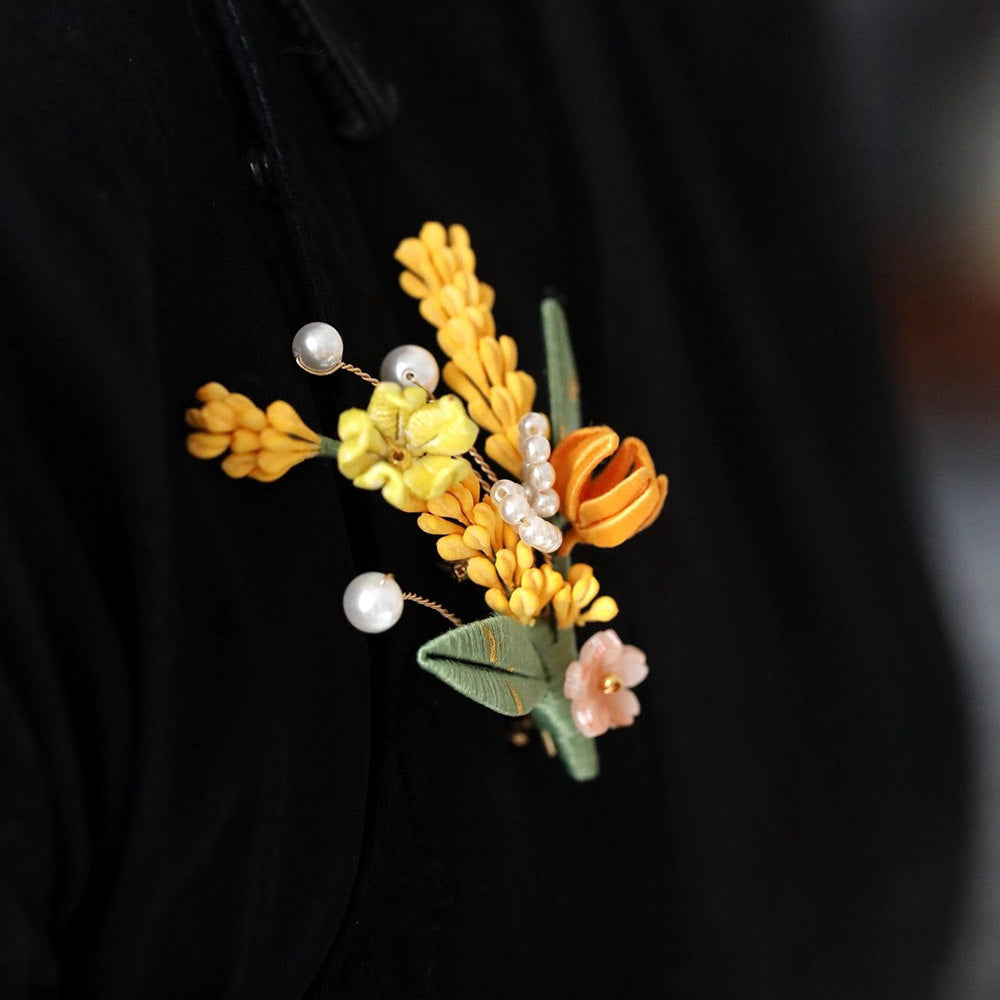 Close-up of brooch worn on fabric showing layered petals and beads